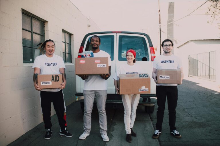 Group of volunteers holding aid boxes, ready to distribute in the community.